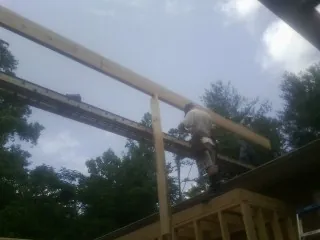 Carpenter setting a ridge beam over a new addition frame — Ice Dam Removal by Roofing Brothers in Swedesboro