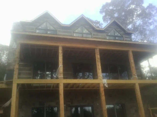 Dormers and porch framing on a large log home under construction — Roof Coating work by our crew in Swedesboro